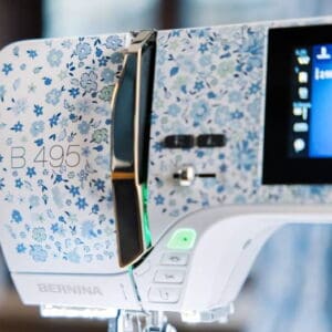 Close-up of a floral-patterned Bernina B 495 sewing machine with its touchscreen display visible on the right.