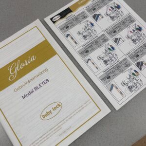 Two instruction sheets for Baby Lock Gloria, one with a gold header reading 'Gloria' and a yellow-bordered page beside a diagram-heavy page set on a gray surface.