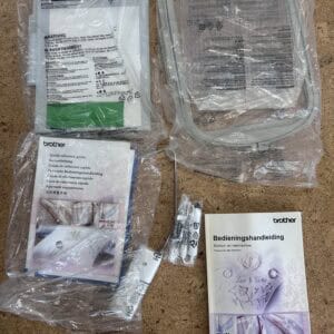 Assorted Brother sewing machine parts and manuals on a cork floor, including a purple-floral Bedieningshandleiding manual.