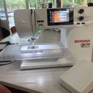 Bernina B435 sewing machine on a showroom counter with touchscreen display and control dials visible.