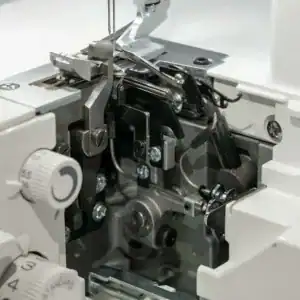 Close-up of a sewing machine's internal metal gears and tension components.