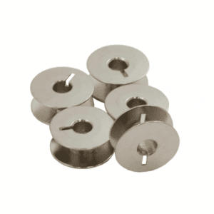 Pile of metal bobbins with central holes and small notches arranged in a cluster.